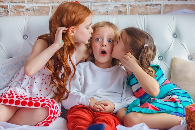 Beautiful children sitting on bed