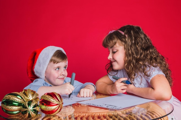 The beautiful children write a letter to Santa Claus. Christmas concept.