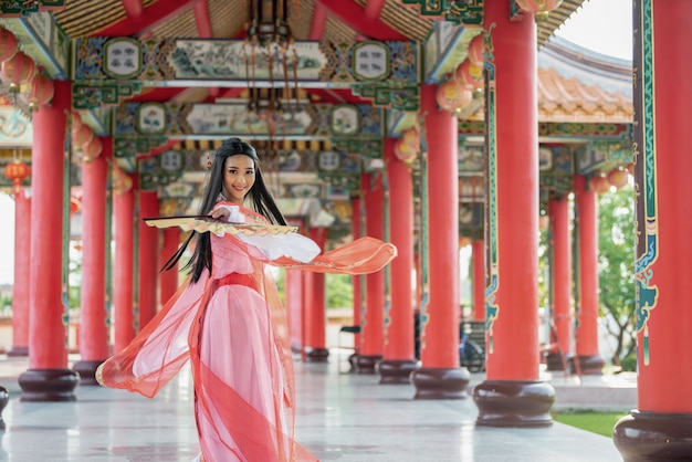 Beautiful Chinese woman with a traditional suit with blow in her hands.