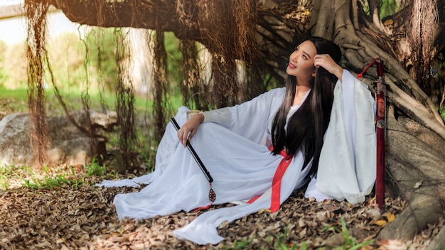 Beautiful Chinese woman with a traditional suit with a flute in her hands.