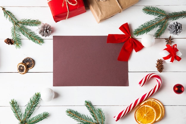 Beautiful Christmas composition on wooden white background. Empty card with Christmas present boxes