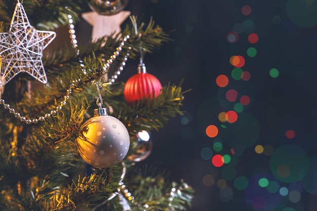 Beautiful Christmas decor concept bauble hanging on the Christmas tree with sparkling light spot blurry dark black background macro detail close up