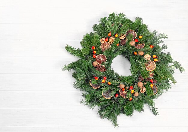 Beautiful Christmas wreath made by professional florist on white wooden background