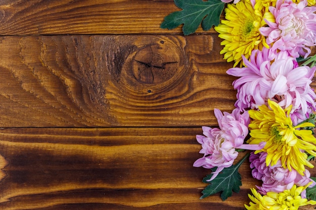 Beautiful chrysanthemums on wooden background. Top view, copy space