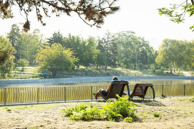 Beautiful city park with lake and sunbeds in sunny morning