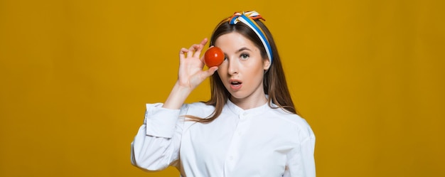 Beautiful closeup portrait of young woman with tomato Healthy food and vegetables concept