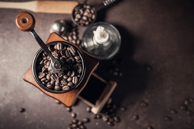 Beautiful coffee grinder and coffee bean on old kitchen table background.