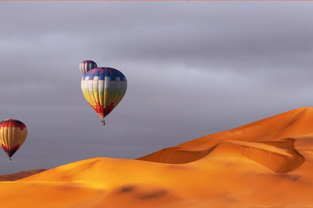 Beautiful Colorful Hot Air Baloons and dramatic clouds over the sand dunes in the Namib desert