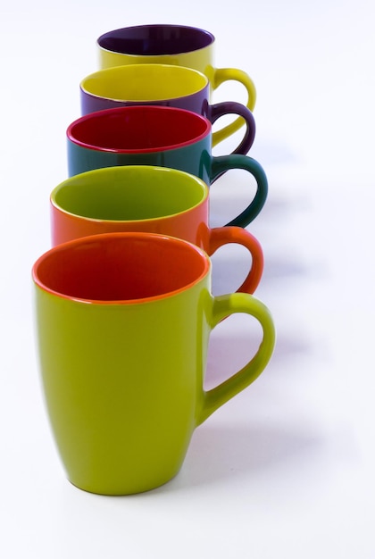 Beautiful colorful porcelain mugs in white background