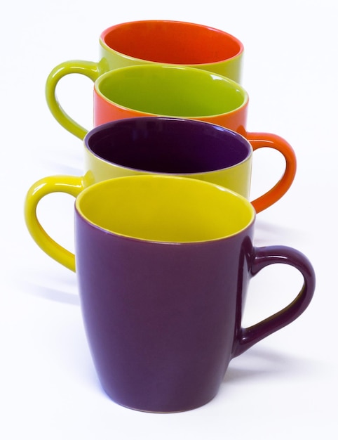 Beautiful colorful porcelain mugs in white background