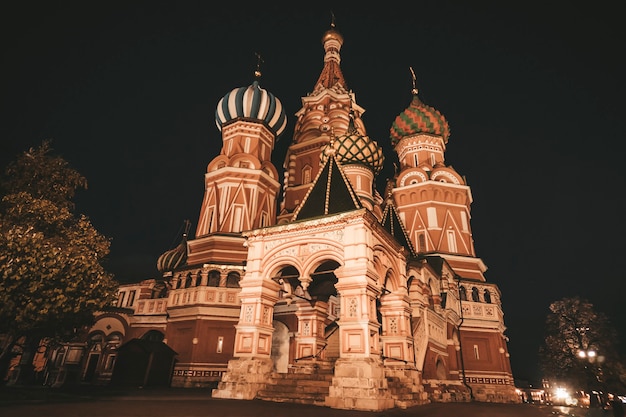 Photo beautiful, colourful, patterned domes of st basil's cathedral in moscow built in true russian style. night view of russian otrhodox church, main architectural building and a symbol of russia. heritage