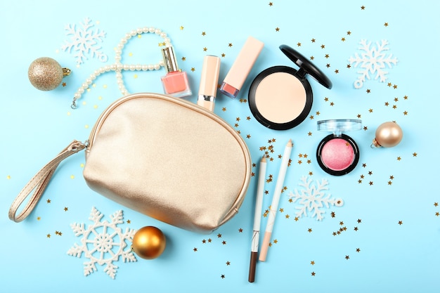 Beautiful composition with christmas decor and makeup cosmetics top view