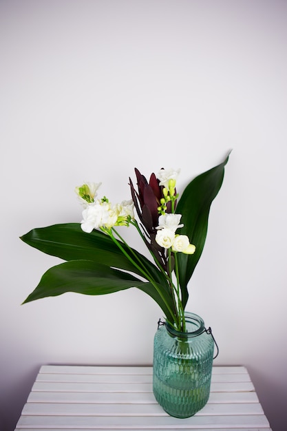 Beautiful composition with fresh freesia in vase on table