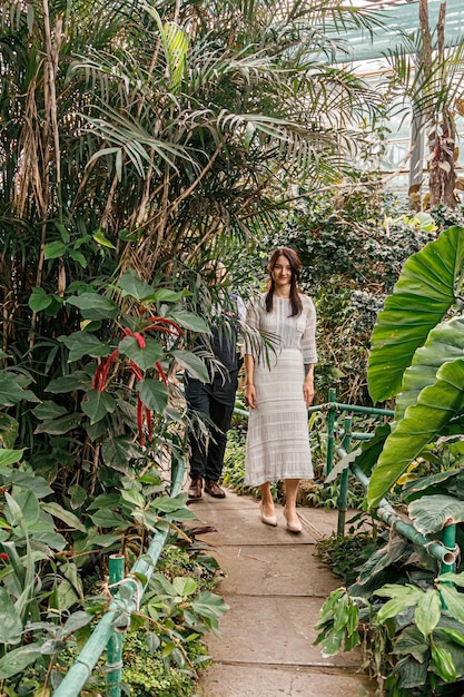 Beautiful couple girl and guy in the park among tropical trees