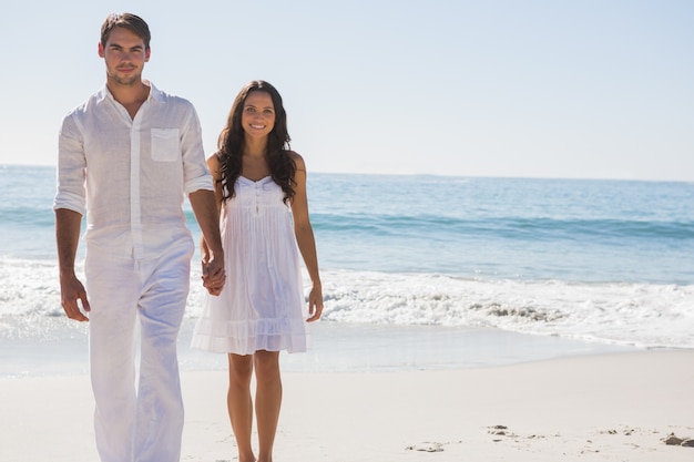 Beautiful couple holding hands and walking towards camera