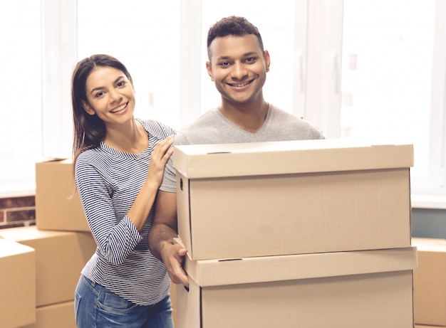 Beautiful couple is holding moving boxes.