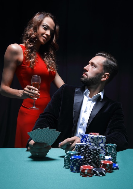 Beautiful couple looking at playing cards at poker