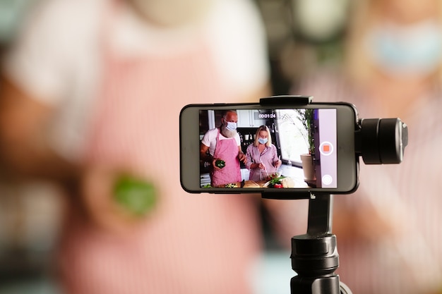 Beautiful couple lover blogger live cooking at kitchen for working from home. COVID-19. Selective focus.