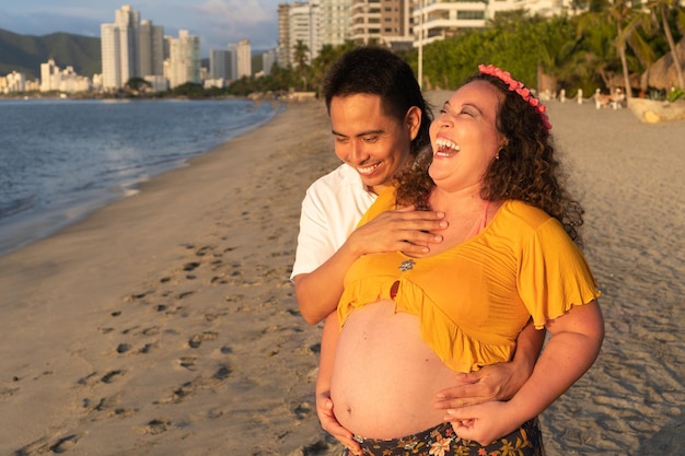 Beautiful couple pregnant woman in the beach