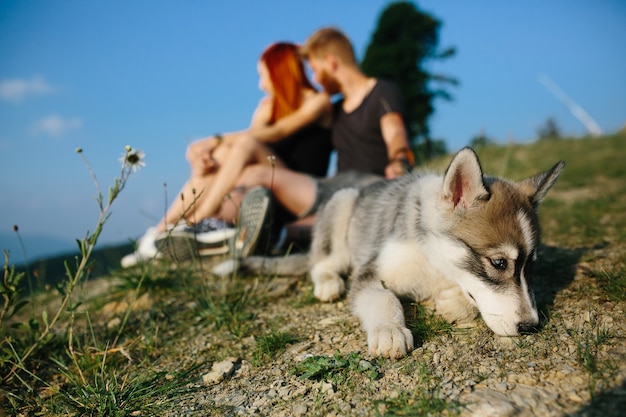 Beautiful couple sits on a hill and hugging each other