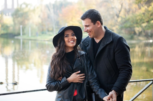 Beautiful couple walking in autumn park near a lake