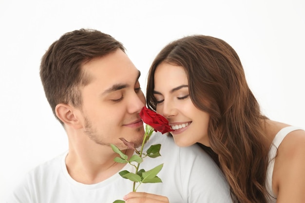 Beautiful couple with rose on light background