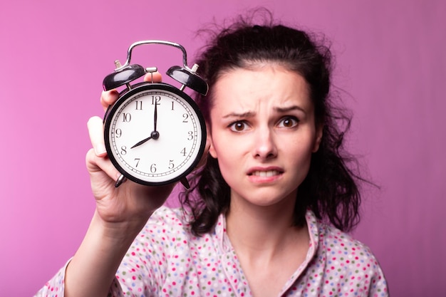 beautiful curly girl in pajamas pink background