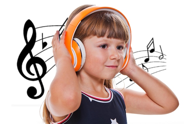 Beautiful cute happy little girl listening music with headphones