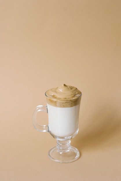 Beautiful dalgon drink coffee with foam in a transparent mug