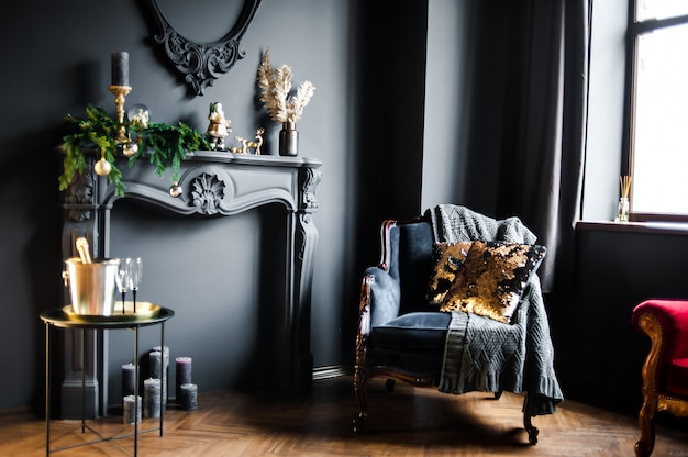 Beautiful dark interior with fake fireplace and armchair