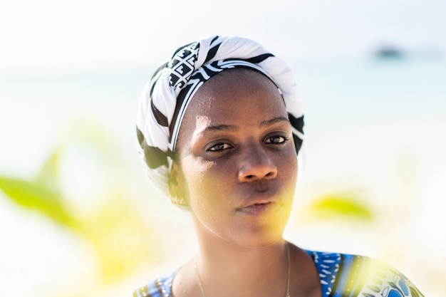 Beautiful dark skin young woman between palm branches on beach photo