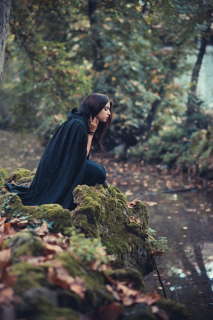 beautiful dark vampire woman with black mantle and hood