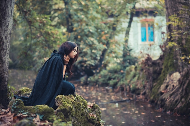 beautiful dark vampire woman with black mantle and hood