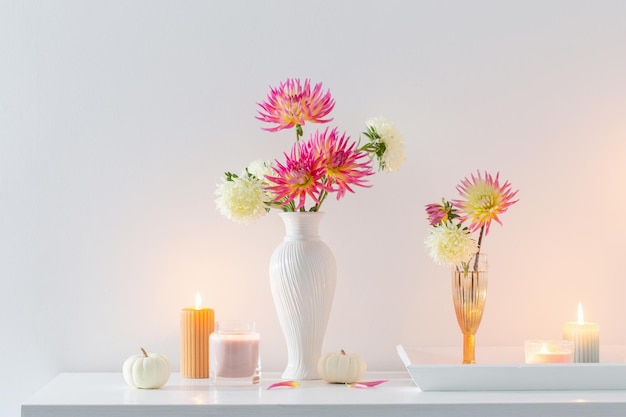 Beautiful decor with flowers pumpkins candles on white background