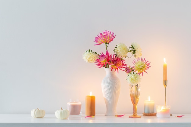 Beautiful decor with flowers pumpkins candles on white background