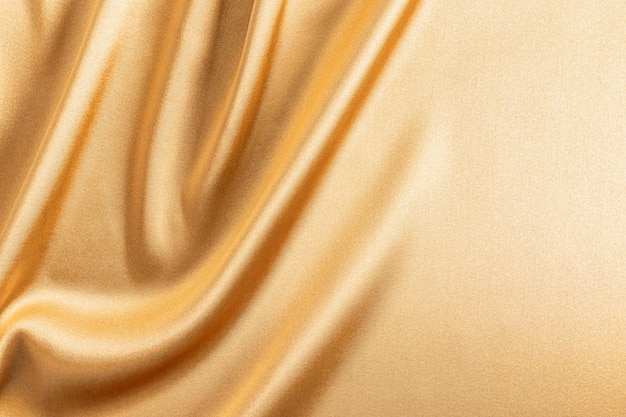 Beautiful delicate background texture of golden fabric delicate folds of fabric drapery Background for product presentation A copy space