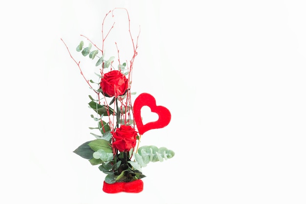 Beautiful delicate bouquet of stabilized flowers rosesdried flowers branches of leaves and with a heart on a white background isolatedselective focusgift bouquet for valentinedeclaration of love