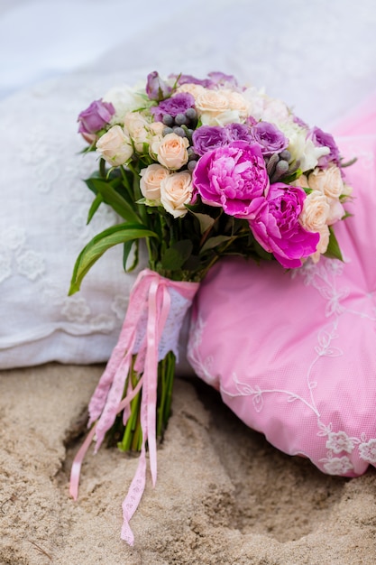 Beautiful, delicate bridal bouquet among decorations with pillow