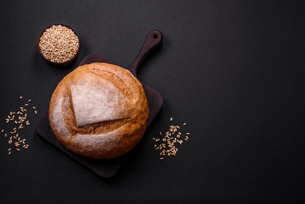 Beautiful delicious freshly baked round shaped white bread on a dark concrete background