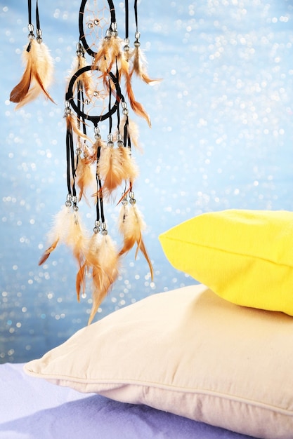 Beautiful dream catcher and pillows on blue background