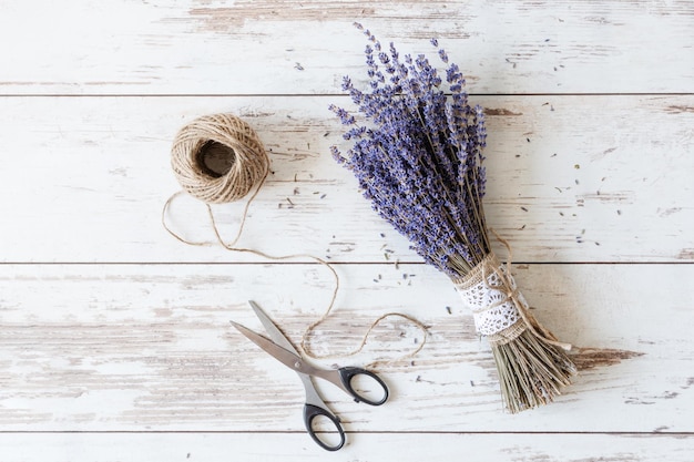 Beautiful dried lavender flowers bunch top view on white wooden background