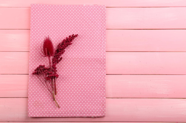 Beautiful dry flowers on napkin on wooden background