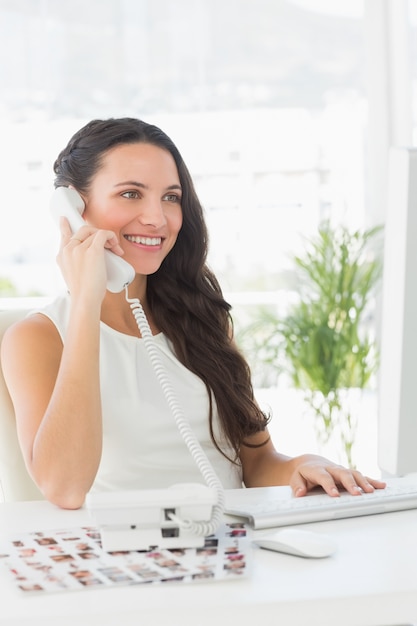 Beautiful editor on telephone at her desk 