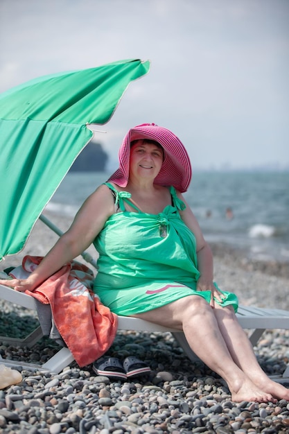 Beautiful elderly woman is relaxing on the beachRetired at the resort