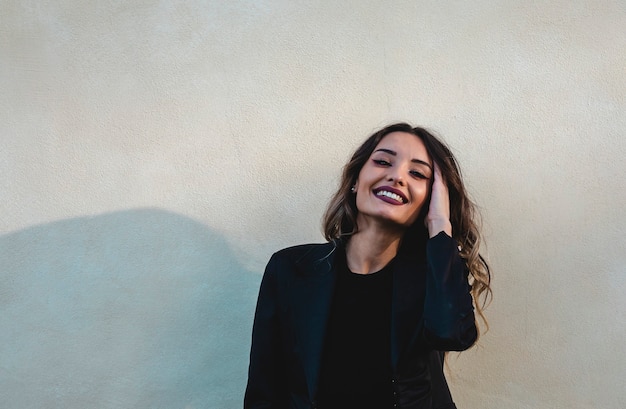 Beautiful elegant woman. Portrait of smiling woman touches her hair.