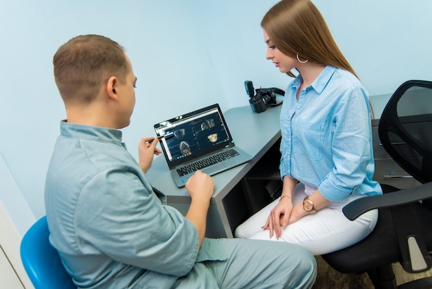 Beautiful emotional girl sitting in a chair next to a male doctor. Dental clinic. Treatment