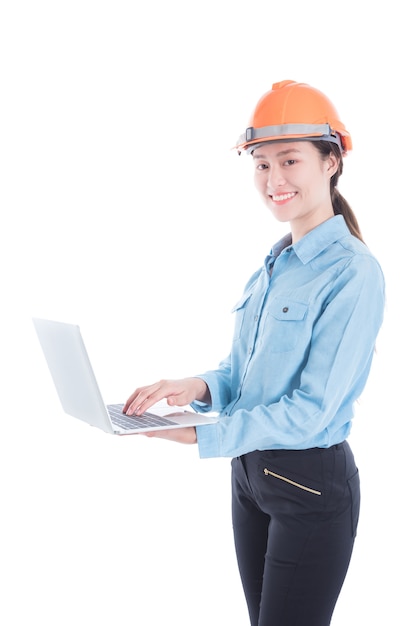 Beautiful engineer woman wearing helmet and using notebook computer 