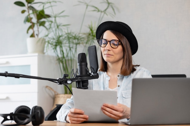 Beautiful european woman podcaster with headphones and microphone records podcast in recording