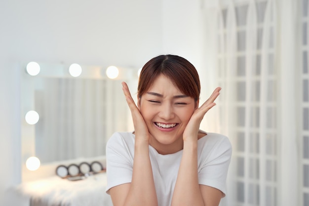 Beautiful face of young smiling Asian woman with clean fresh skin