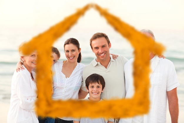 Beautiful family at the beach against house outline in clouds